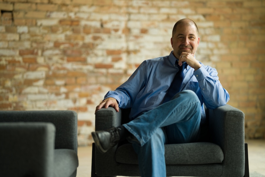Adult man seated in therapy chair, thoughtful