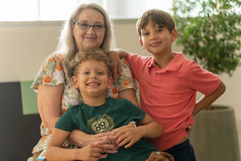 Smiling woman with two children at Unison Health mental health care center